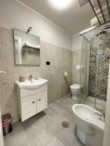 a bathroom with a sink and a shower and a toilet at ALDIVA ROOMS in Torvaianica
