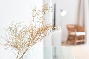 a vase filled with dried flowers sitting on a table at Rooms & Suites Loft 2G Deluxe Edition Arrecife in Arrecife