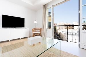 a white living room with a flat screen tv at Rooms & Suites Loft 2G Deluxe Edition Arrecife in Arrecife