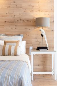 a bedroom with a bed and a table with a lamp at Rooms & Suites Loft 2G Deluxe Edition Arrecife in Arrecife