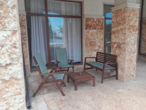 three chairs and a coffee table on a patio at Balchik Gardens complex SeaHome 21 apartment in Balchik