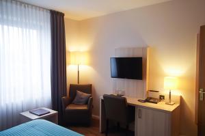 Breitenfelde的住宿－高歇曼酒店，酒店客房配有书桌和椅子