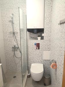 a bathroom with a toilet and a glass shower at Balchik Gardens complex SeaHome 21 apartment in Balchik