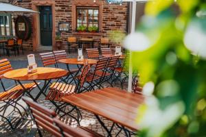 RATSKELLER Hotel & Restaurant في كروف: فناء في الهواء الطلق مع طاولات وكراسي خشبية