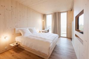 a bedroom with a large white bed and a window at Bader Hotel in Parsdorf +18 photos