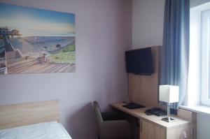 ein Hotelzimmer mit einem Bett und einem Schreibtisch mit einer Lampe in der Unterkunft Gothmann´s Hotel in Breitenfelde