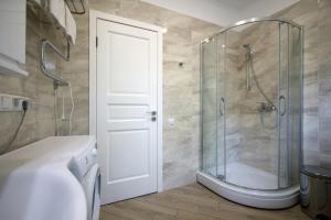 a bathroom with a shower with a glass door at Alve Apart Hotel in Jūrmala