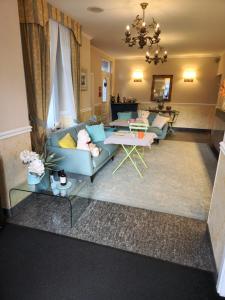 Hotel Millennium في لوكارنو: غرفة معيشة مع أريكة زرقاء وطاولة
