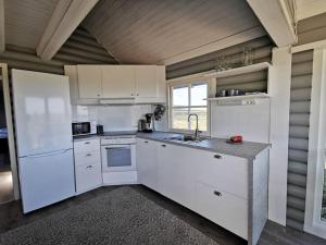 a kitchen with white cabinets and a sink at Kieppi, open your door and enjoy the wilderness in Utsjoki