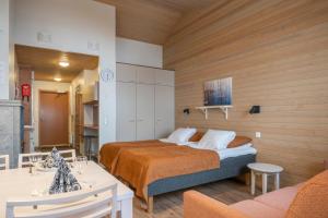 a bedroom with a bed and a living room at Ski-Inn AurinkoRinne in Ruka