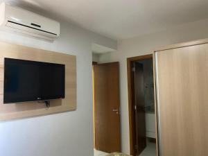 um quarto com uma televisão de ecrã plano na parede em Flat 405 - Condomínio Veredas do Rio Quente - Diferenciado com ar na sala e no quarto em Rio Quente