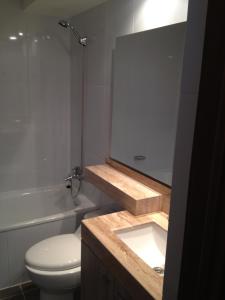 a bathroom with a sink and a toilet and a mirror at Apartment Isa Concón in Concón