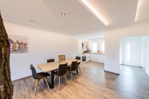 a dining room and kitchen with a table and chairs at Ferienpark Harkebrügge Haus Spiekeroog in Barßel