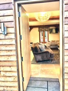 a living room with a couch and a chandelier at Quality Oak Barn with Hot Tub and Parking in Bramley