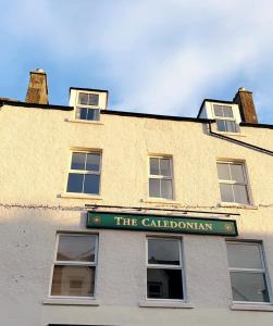 um edifício com um sinal que lê o caledoniano em The Caledonian em Portree