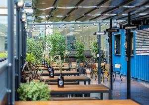 un patio avec des bancs, des tables et des plantes en bois dans l'établissement BrewDog DogHouse Manchester, à Manchester