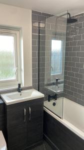 a bathroom with a sink and a tub and a shower at Modern Luxury Flat in London in Hither Green