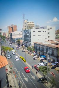 una concurrida calle de la ciudad con coches en la carretera en Unión Plaza Hotel, en Cochabamba