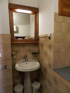 een badkamer met een wastafel en een spiegel bij Casa Nonna Elisa in Scanno