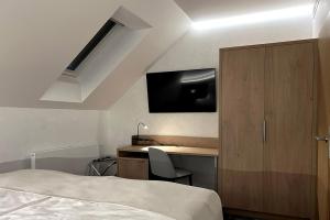 a bedroom with a bed and a desk and a tv at Duran Penzion in Hradec Králové