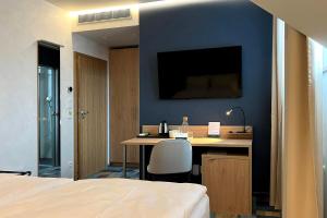 a bedroom with a desk and a tv on a blue wall at Duran Penzion in Hradec Králové