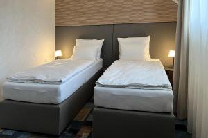 2 Betten nebeneinander in einem Zimmer in der Unterkunft Duran Penzion in Hradec Králové