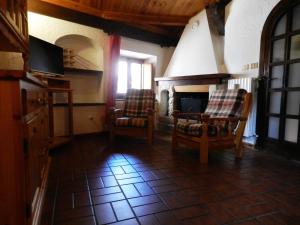 een woonkamer met 2 stoelen en een open haard bij Casa Nonna Elisa in Scanno