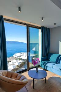 a living room with a couch and a view of the ocean at Hotel Nertili in Sarandë