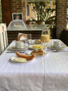 una mesa con platos de comida en un mantel blanco en Suites de Charme Amoremio, en Arraial d'Ajuda