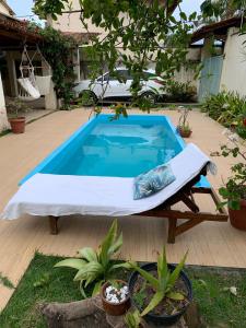 una piscina con cama en un patio en Casa Tropical Arraial D' Ajuda, en Arraial d'Ajuda
