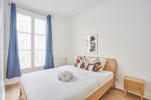 - une chambre avec un lit doté de rideaux bleus et d'une fenêtre dans l'établissement Residence Neuilly Bois de Boulogne by Studio prestige, à Neuilly-sur-Seine