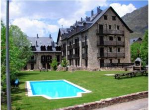 a large building with a swimming pool in front of it at Apartamento Herbasabina 3 con jardín comunitario y piscina en verano in Pla de l'Ermita