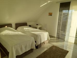 sypialnia z 2 łóżkami, oknem i dywanem w obiekcie Ferienhaus Deußen w mieście Erftstadt