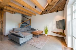 a living room with a couch and a tv at Ferienpark Harkebrügge Haus Borkum in Barßel