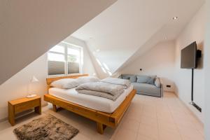 a bedroom with a bed and a couch in a attic at Ferienpark Harkebrügge Haus Borkum in Barßel