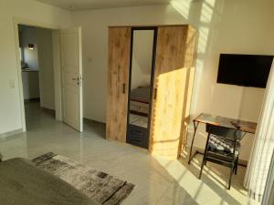 Zimmer mit einem Schlafzimmer mit einem Spiegel und einem Schreibtisch in der Unterkunft Ferienhaus Deußen in Erftstadt