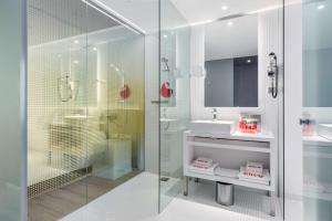 a bathroom with a glass shower and a sink at nhow Rotterdam in Rotterdam