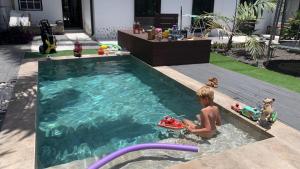 um rapaz a brincar numa piscina com brinquedos em Villa Mamita em Los Llanos de Aridane