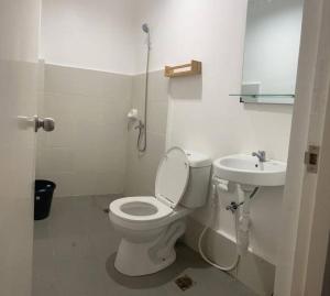 La salle de bains blanche est pourvue de toilettes et d'un lavabo. dans l'établissement Deluxe studio unit at Modena Town Sq, à Tunghaan