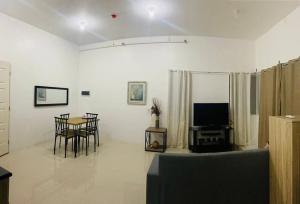 - un salon avec une table, des chaises et une télévision dans l'établissement Deluxe studio unit at Modena Town Sq, à Tunghaan