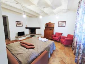 um quarto com uma cama, 2 cadeiras e uma lareira em Property in Gambassi Terme FI em Gambassi Terme