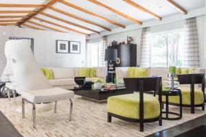 a living room with a white couch and yellow chairs at The Manor House by The Getaway Collection in Grândola