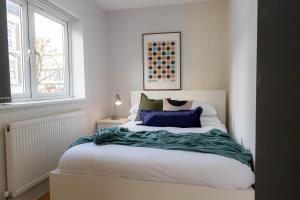 a bedroom with a bed with a blue blanket on it at Camden Apartments Next to Market and Tube Station in London