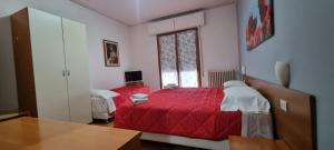 una camera con letto rosso e finestra di Hotel Indicatore Budget & Business At A Glance a Campi Bisenzio