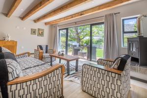 a living room with couches and a table and a tv at Mimosa Lodge in Montagu