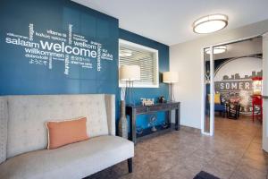 a living room with a couch and a blue wall at Sonesta Simply Suites Somerset in Somerset