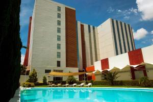a hotel with a swimming pool in front of a building at Bel Air Business Salamanca, Trademark by Wyndham in Salamanca
