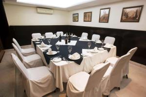 a conference room with a long table and white chairs at Bel Air Business Salamanca, Trademark by Wyndham in Salamanca