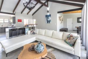 a living room with a white couch and a table at Mimosa Lodge in Montagu