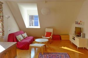 a living room with a red couch and a tv at Ferienwohnung Ybbsperle in Waidhofen an der Ybbs